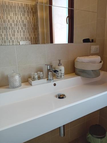 a bathroom with a white sink and a mirror at B&B Tra mare e montagna - sauna e piscina in San Giorgio di Pesaro