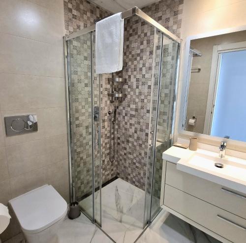 a bathroom with a shower and a toilet and a sink at Sunset Drive Apartments in Benidorm
