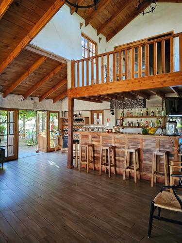 uma grande cozinha com um bar com bancos de madeira em Parronales de Los Boldos em Santa Cruz