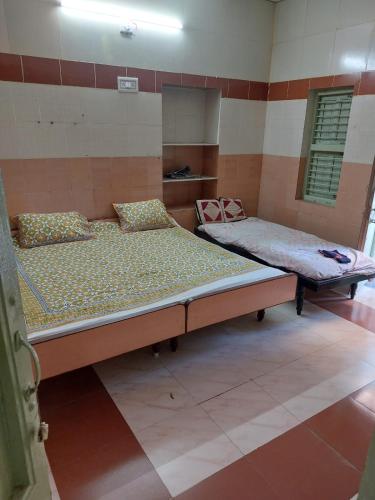 two beds sitting in a room with at Ram Nivas Home Stay Dwarka in Dwarka
