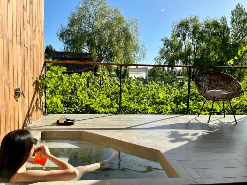 una mujer está sentada en una piscina en Parronales de Los Boldos en Santa Cruz