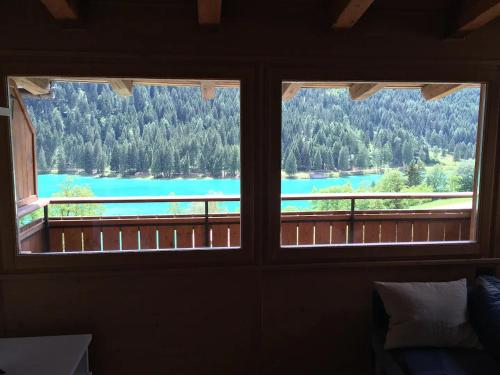 een raam met uitzicht op een meer vanuit een huis bij Mansarda vista lago in Auronzo di Cadore