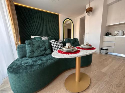 ベオグラードにあるBeldorado Apartments - Belgrade Waterfront Luxury Apartment Amberのリビングルーム(ソファ、ケーキ付きテーブル付)