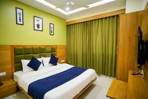 a bedroom with a large bed and a window at Hotel Suncity in Ahmedabad