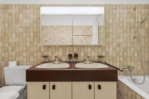 uma casa de banho com 2 lavatórios, um espelho e um WC em Neumünsterstrasse 26 em Zürich