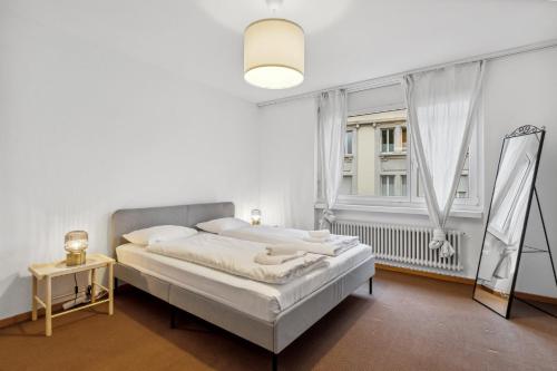 um quarto branco com uma cama e uma janela em Neumünsterstrasse 26 em Zürich