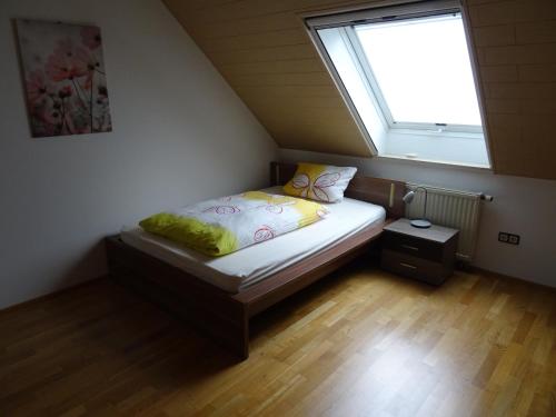 a small bed in a room with a window at Ferienwohnung Frieda in Nüdlingen