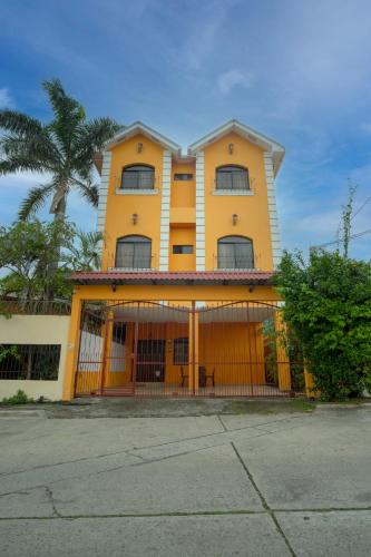a yellow building with a gate in front of it at Apart hotel la Trejo in San Pedro Sula