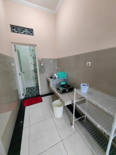 a bathroom with a sink and a shower with a mirror at pondok Syariah Hadikusuma 