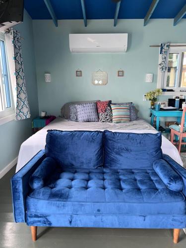 a blue couch in a room with a bed at Dockside Utila Ocean front suites in Utila