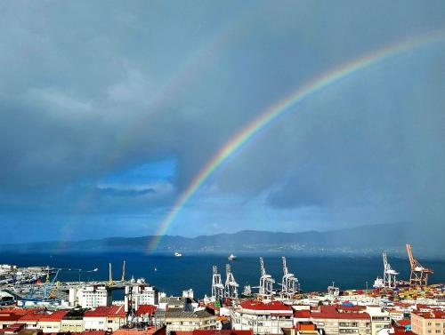 a rainbow in the sky over a city at VistasAragon in Vigo