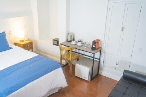 Un dormitorio con una cama y una mesa con un hervidor de agua. en Bella Tilcara Boutique Hotel en Tilcara