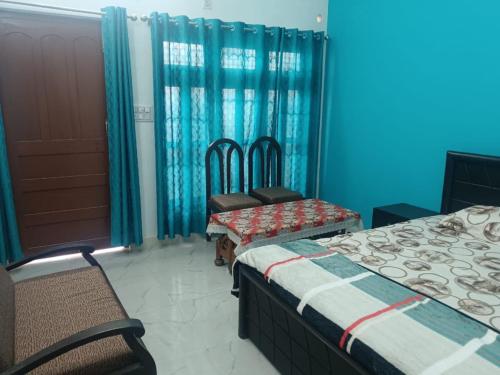 um quarto com duas camas e duas cadeiras e uma porta em Maa vaishno paying guest house em Ayodhya