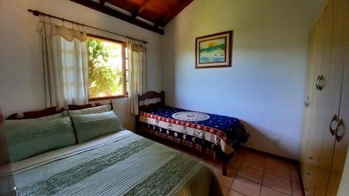 1 dormitorio con 2 camas y ventana en Casa Vista Panorâmica, en Florianópolis