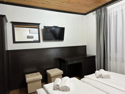 Cette chambre comprend 2 lits et une télévision à écran plat. dans l'établissement Готельний комплекс Парламент, Яблуниця, à Yablunytsya