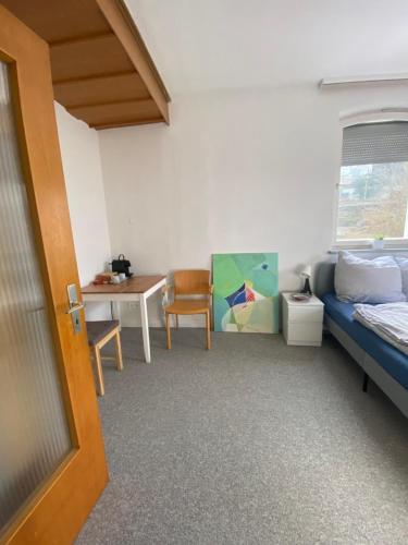 a room with a bed and a table and a chair at Bluestone Appartments 25qm free and near parking in Blaustein