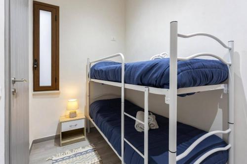 Zimmer mit 2 Etagenbetten und blauen Kissen in der Unterkunft Tampasio Apartment Trapani centro in Trapani