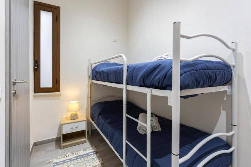 a room with two bunk beds with blue pillows at Tampasio Apartment Trapani centro in Trapani