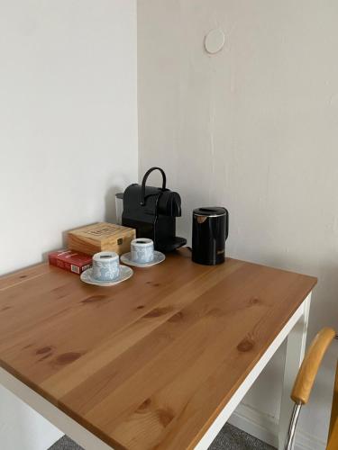 a wooden table with two cups on top of it at Bluestone Appartments 25qm free and near parking in Blaustein