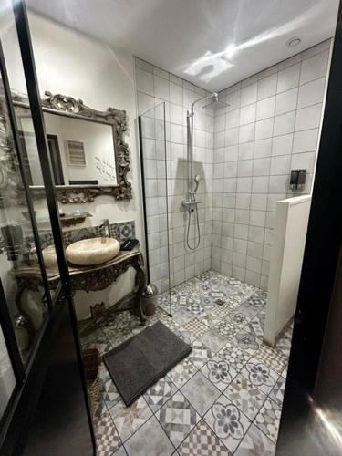 a bathroom with a sink and a shower with a mirror at Au domaine des anges, 3 gîtes luxueux avec Jacuzzi privatif, sauna, mini-piscine, piscine extérieure chauffée en saison in Bain-de-Bretagne