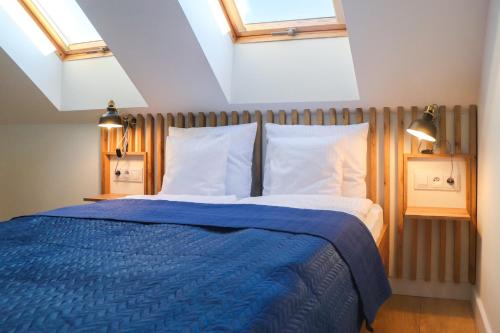 a bedroom with a blue bed with two pillows at Apartamenty Parkowa 9 in Lesko