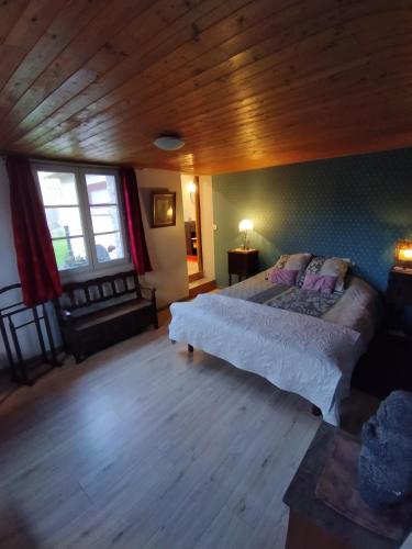 - une chambre avec un grand lit et un plafond en bois dans l'établissement Chambres d'hôtes du chemin de la maison blanche, à West-Cappel