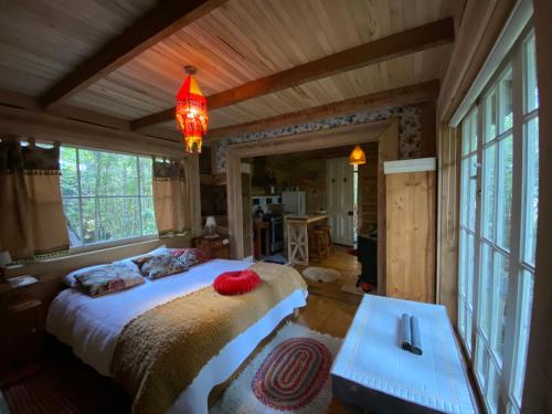 um quarto com uma cama grande num quarto com janelas em La Casita del Bosque em Castro