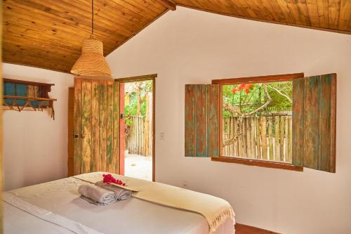 a bedroom with a bed and a window at Casa Baleia - Caraíva - 100m da Igreja in Caraíva