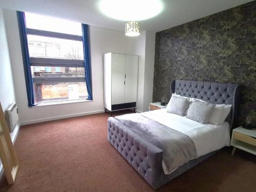 a bedroom with a large bed and a large window at Cutlass Court Apartments by Comfort Zone in Birmingham