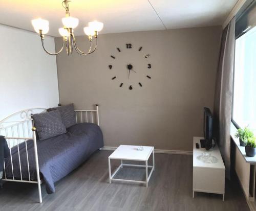 コウヴォラにあるValoisa & tilava 3.krs kaksio, lasitettu parvekeのリビングルーム(青いソファ、壁掛け時計付)