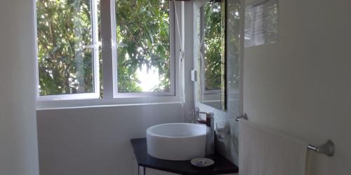 a bathroom with a sink and a window at Real Mauritius Apartments in Grand Gaube