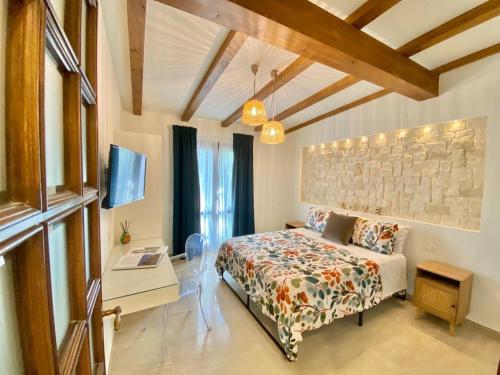 a bedroom with a bed and a table and a tv at Casa vacanza Il Mandarino in Viagrande