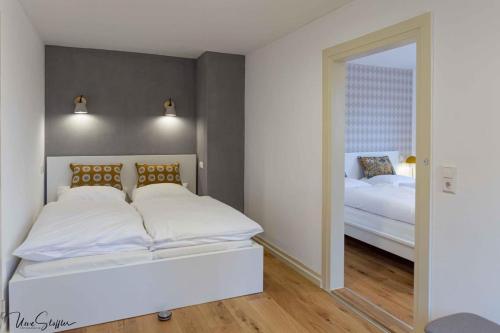 sypialnia z dużym białym łóżkiem i lustrem w obiekcie Ferienhaus Honey Bee w mieście Billingsbach