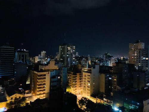 une ville éclairée la nuit avec des bâtiments dans l'établissement Green Wood, à Rosario