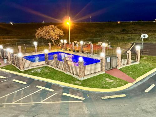 a pool with lights in a parking lot at night at THE COUNTRY CORNER INN in Devine