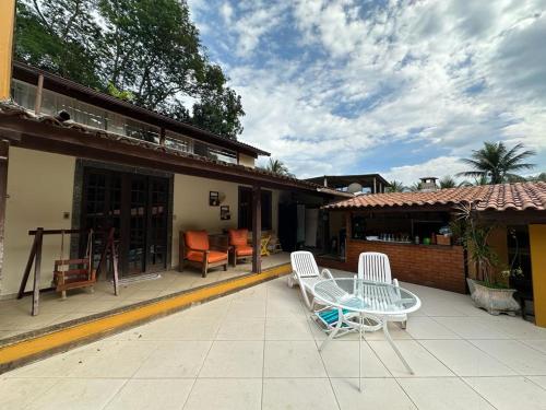 patio z dwoma krzesłami i stołem na domu w obiekcie Quarto Ponta Negra w mieście Angra dos Reis