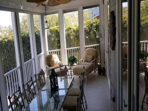 a screened in porch with a glass table and chairs at Gorgeous Bay Side Home! in Harvey Cedars