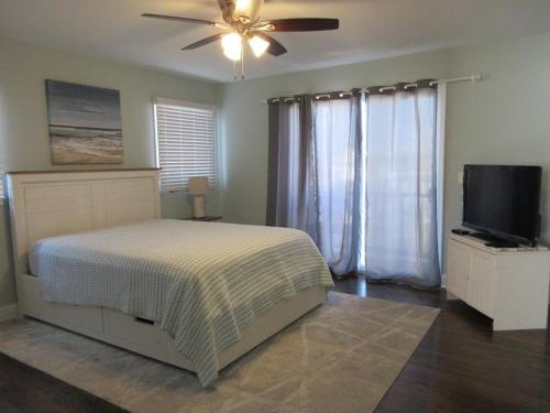 une chambre avec un lit et une télévision à écran plat dans l'établissement Single Family On The Ocean Side Block In Brant Beach Very Nicely Appointed!, à Brant Beach