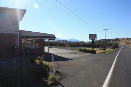 an empty street next to a building with a speed limit sign at A-1 Budget Motel in Klamath Falls