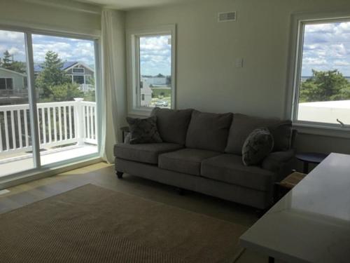 a living room with a couch and large windows at 4Th From The Ocean! Sleeps 10! in Harvey Cedars
