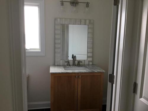 a bathroom with a sink and a mirror at 4Th From The Ocean! Sleeps 10! in Harvey Cedars