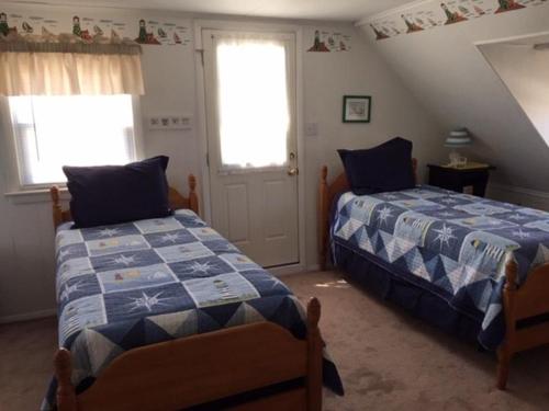 a bedroom with two beds and two windows at Close To Ocean In The Crest in Beach Haven Crest