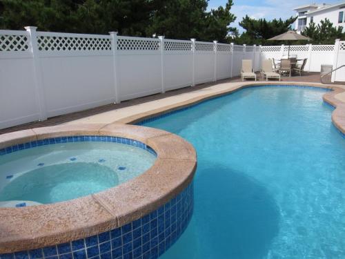 una gran piscina con una valla blanca en Beautiful Private Ocean Front Home, en Loveladies