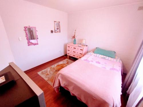 ein kleines Schlafzimmer mit einem Bett und einer Kommode in der Unterkunft Habitación hogareña in Curicó