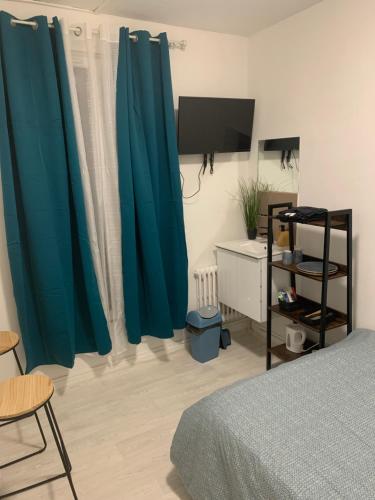- une chambre avec des rideaux bleus, un lit et une télévision dans l'établissement Hotel La Défense, à Colombes