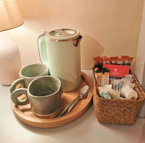 a tray with cups and a tea pot and a basket at Homestay close to the hospital and Alton Towers with resident dog and cat in Stoke on Trent