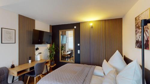 a bedroom with a bed and a table and a desk at CROWN LIVING Studios - Studio für 2 Personen - Sitzplatz auf der Terrasse - kostenloser Parkplatz - Self Check-in in Dornbirn