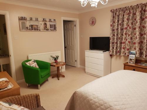 a bedroom with a bed and a tv and a chair at Barn Court Bed and Breakfast in Everton