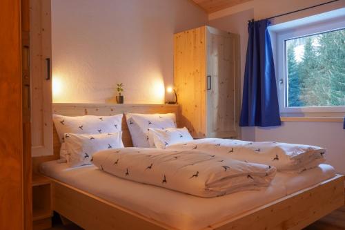 a bedroom with two beds with pillows and a window at Appartementhaus Bergkristall in Kartitsch