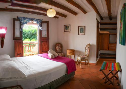 a bedroom with a bed and a table and chairs at Hotel Casa El Mandarino By MH in Barichara